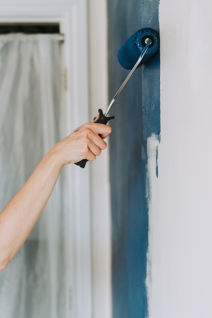 Close-up of a paint roller applying a fresh coat of colour